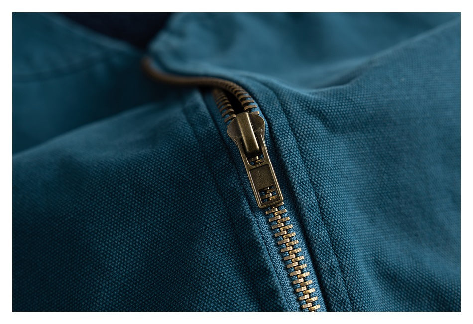 Close-up of a brass-tone zipper on teal textured fabric.