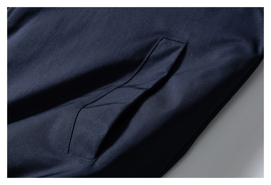 Close-up of a slanted welt pocket on a dark navy jacket.