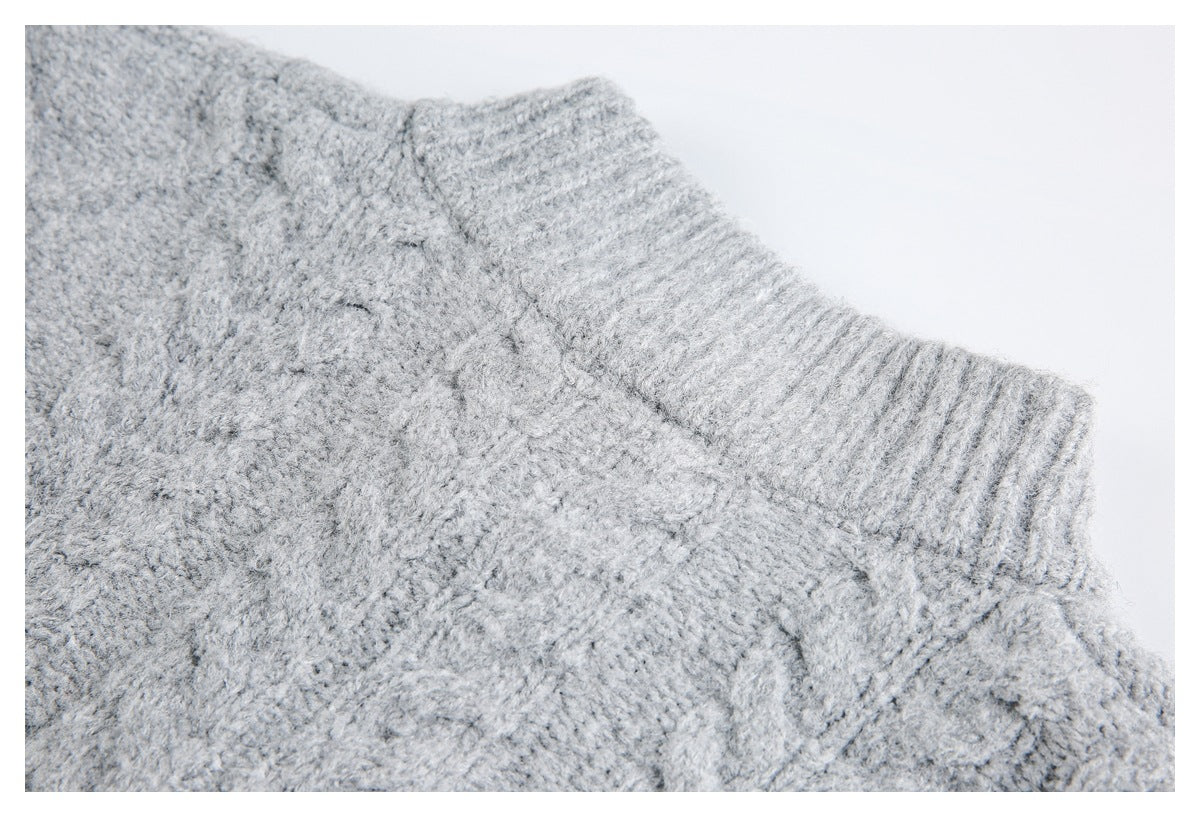 Close-up of light gray textured knit fabric beside a ribbed sweater edge.