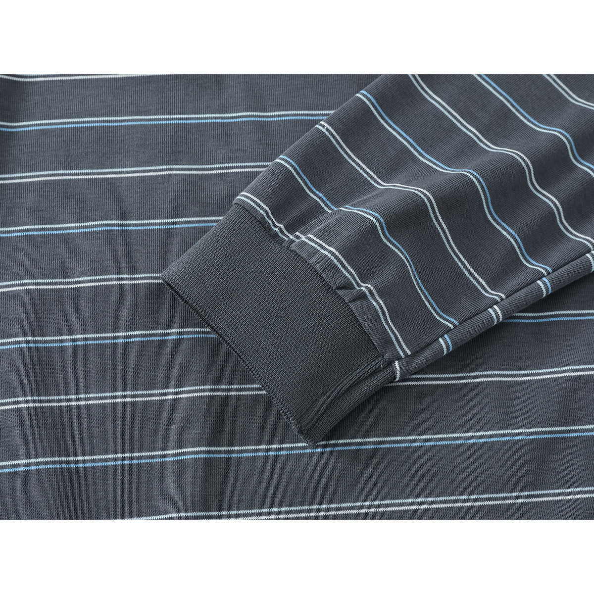 Close-up of a charcoal polo sleeve and ribbed cuff with thin white and blue stripes.