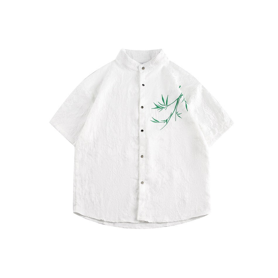White short-sleeve stand-collar shirt with textured fabric, snap buttons and green embroidered bamboo on the chest