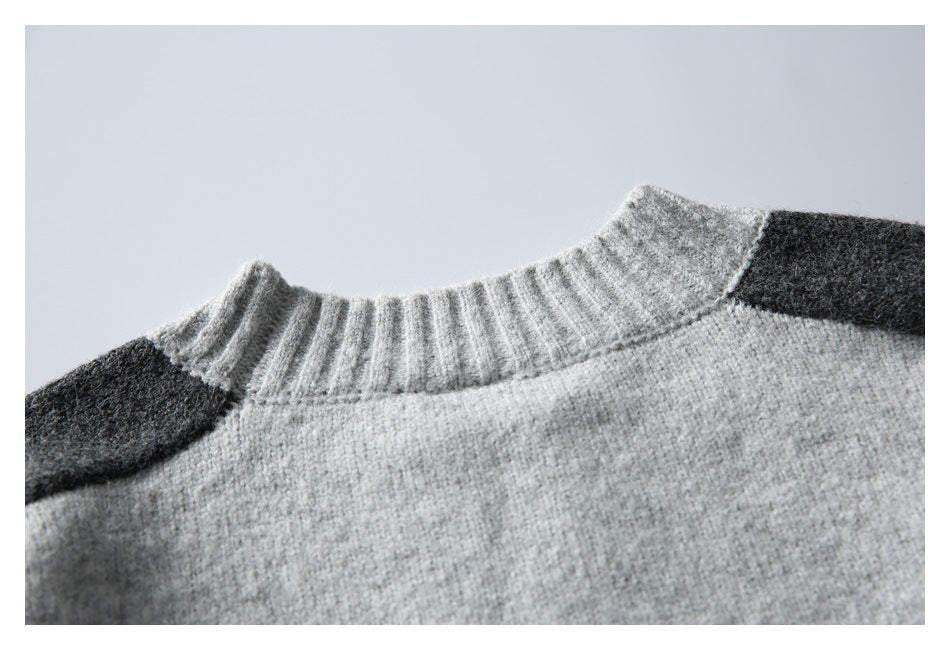 Close-up of the gray sweater's ribbed neckline and dark shoulder panels.