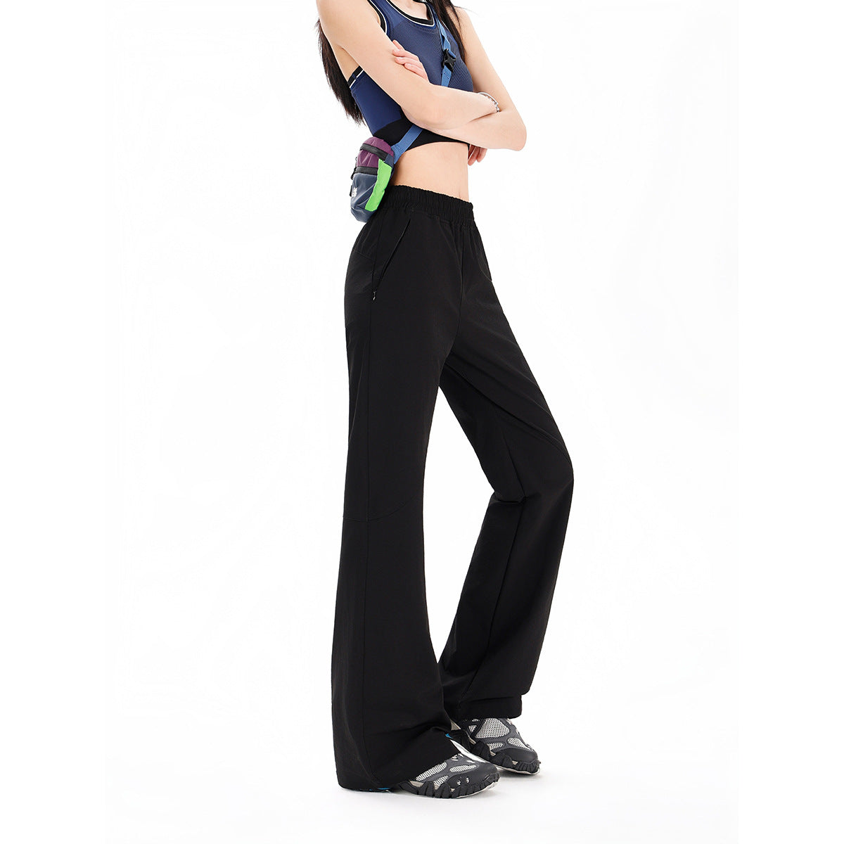 Model wearing black wide-leg pants with an elastic waist and angled zip pockets.