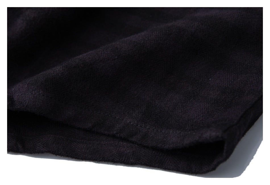 Close-up of a folded edge of dark, nearly black shirt fabric.