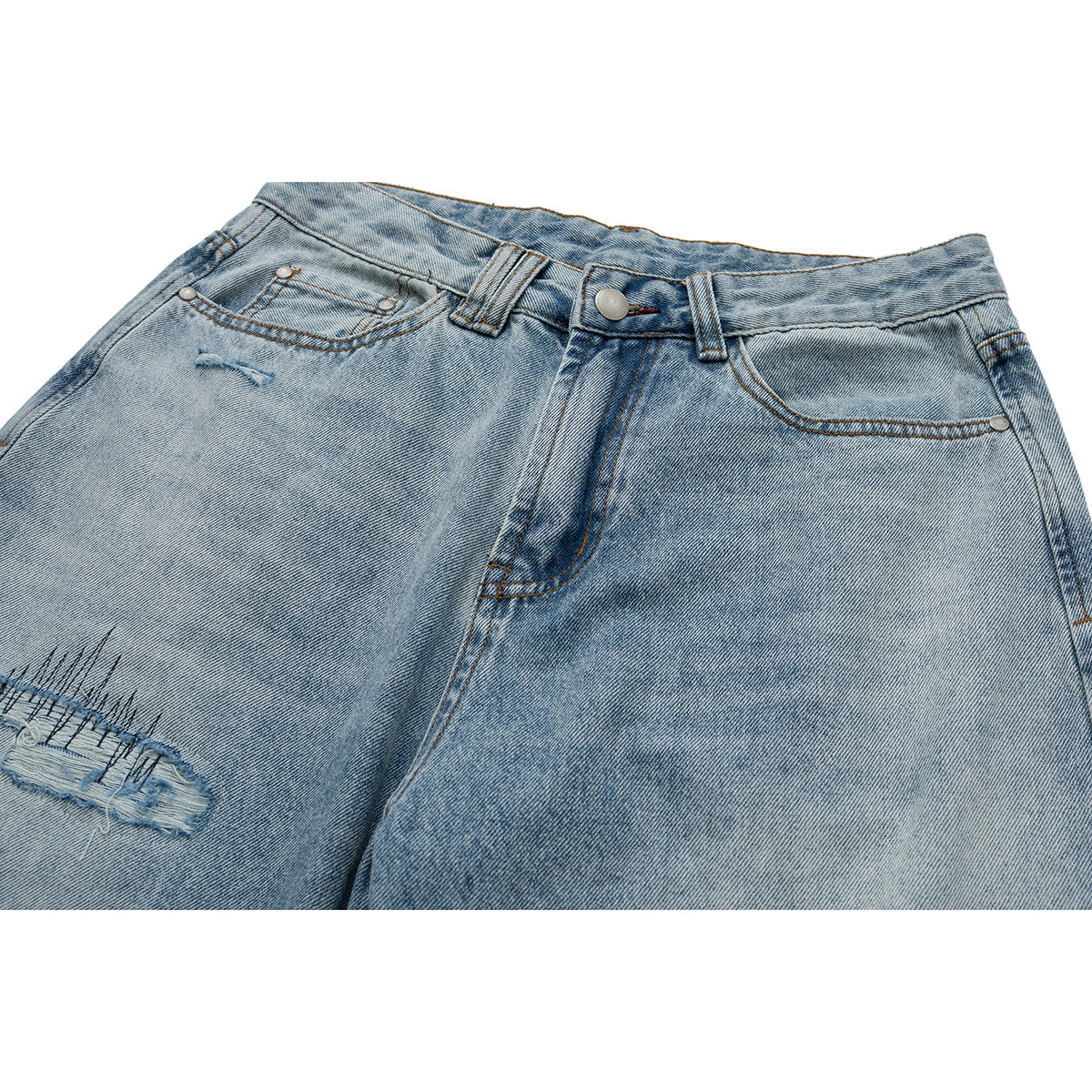Close front view of light-wash jeans showing the waistband, pockets, and a distressed thigh tear.