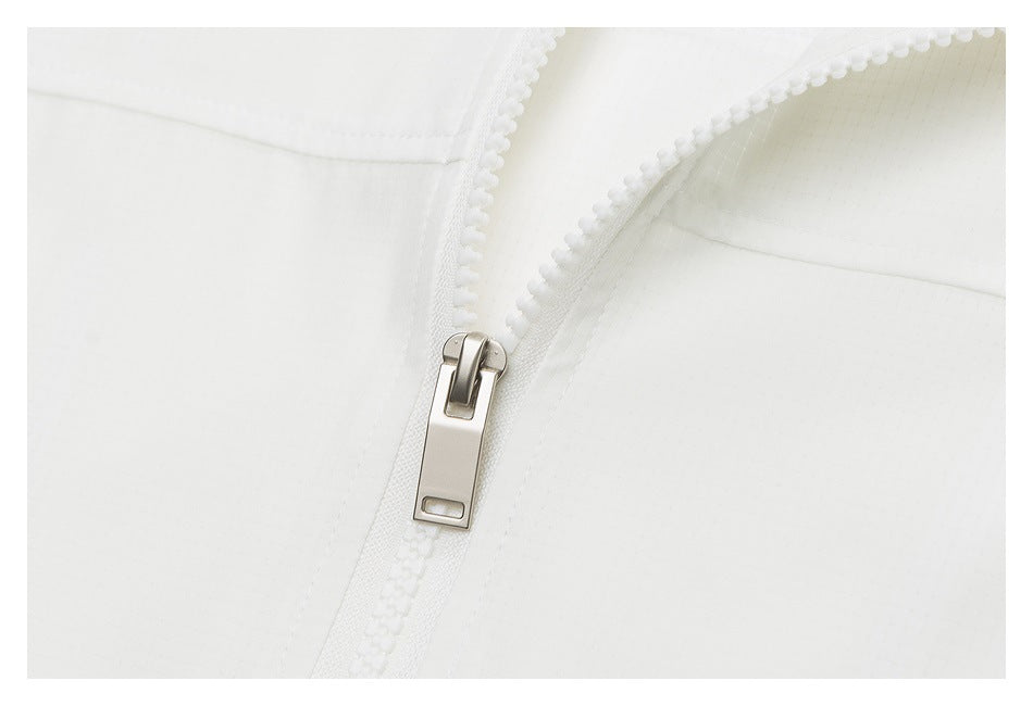 Close-up of a chunky white zipper with a metal pull on white fabric.