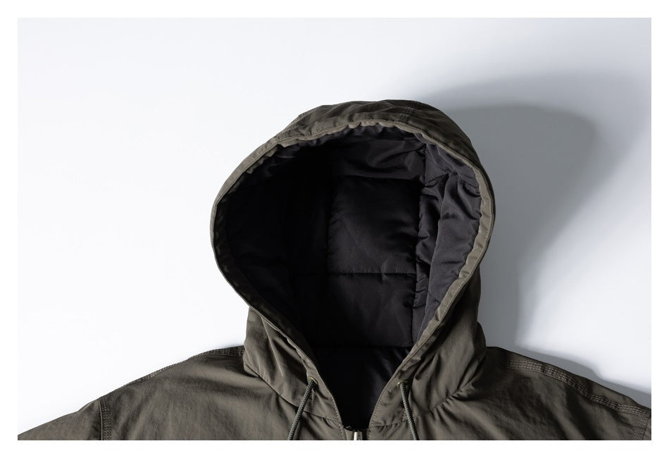 Front close-up of an olive hooded jacket showing its black quilted lining and drawstrings.