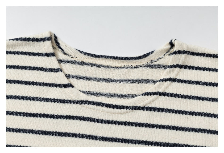 Close-up of the cream knit top's rounded neckline and narrow charcoal stripes.