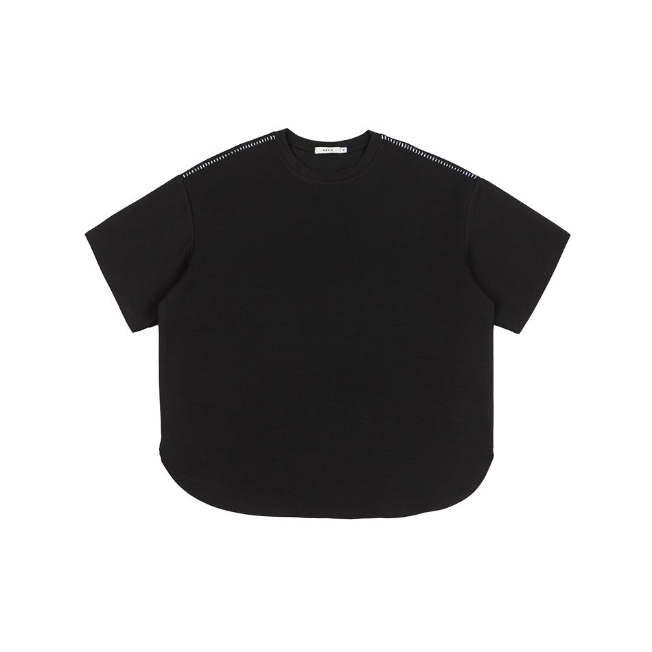 Black short-sleeve crew neck T-shirt flat lay with curved hem and contrast stitching along the shoulders