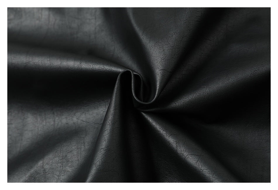 Close-up of black textured material gathered into a twist, showing its surface and drape.