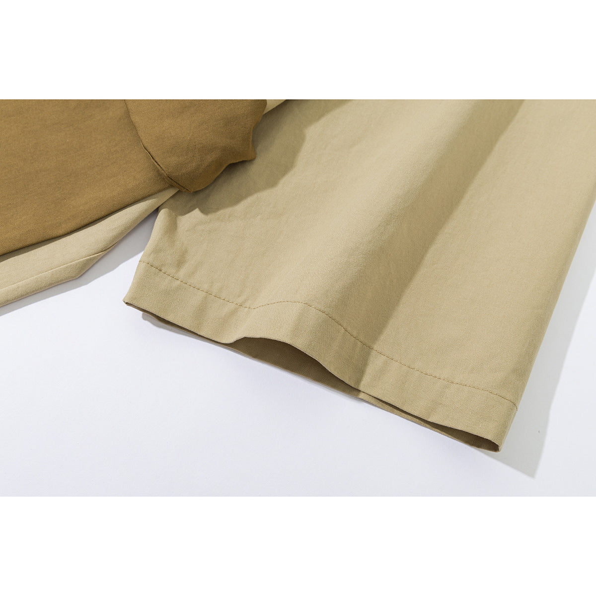 Close-up of the beige jacket's sleeve cuff and stitched hem.
