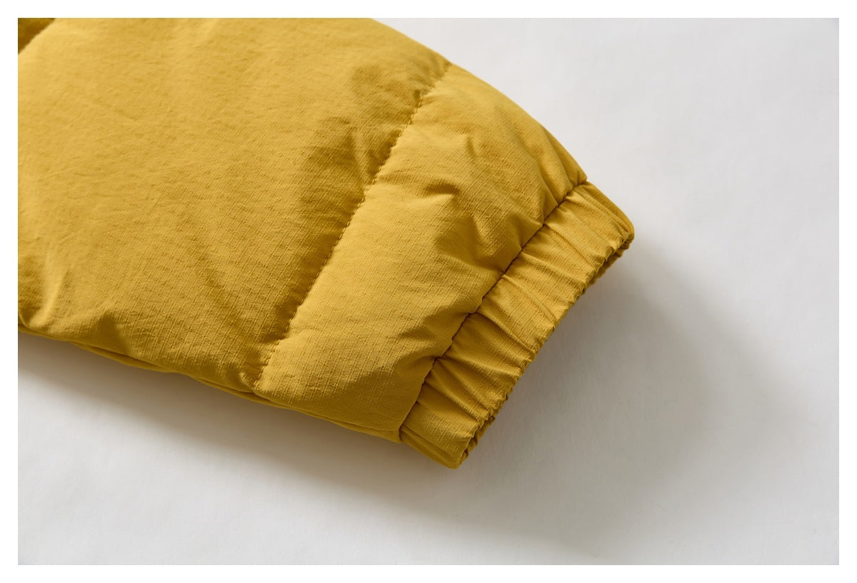 Close-up of a mustard-yellow jacket sleeve and its gathered elastic cuff.