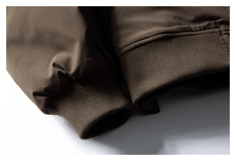 Close-up of the brown jacket's ribbed knit cuffs and sleeve fabric.