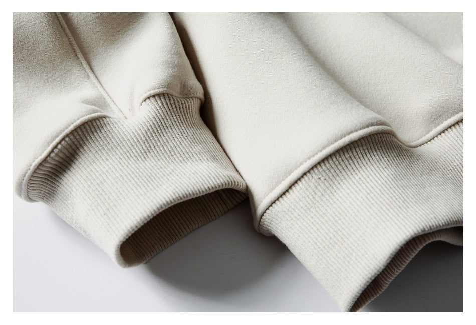 Close-up of a light cream sweatshirt's ribbed cuffs and soft-looking fabric.