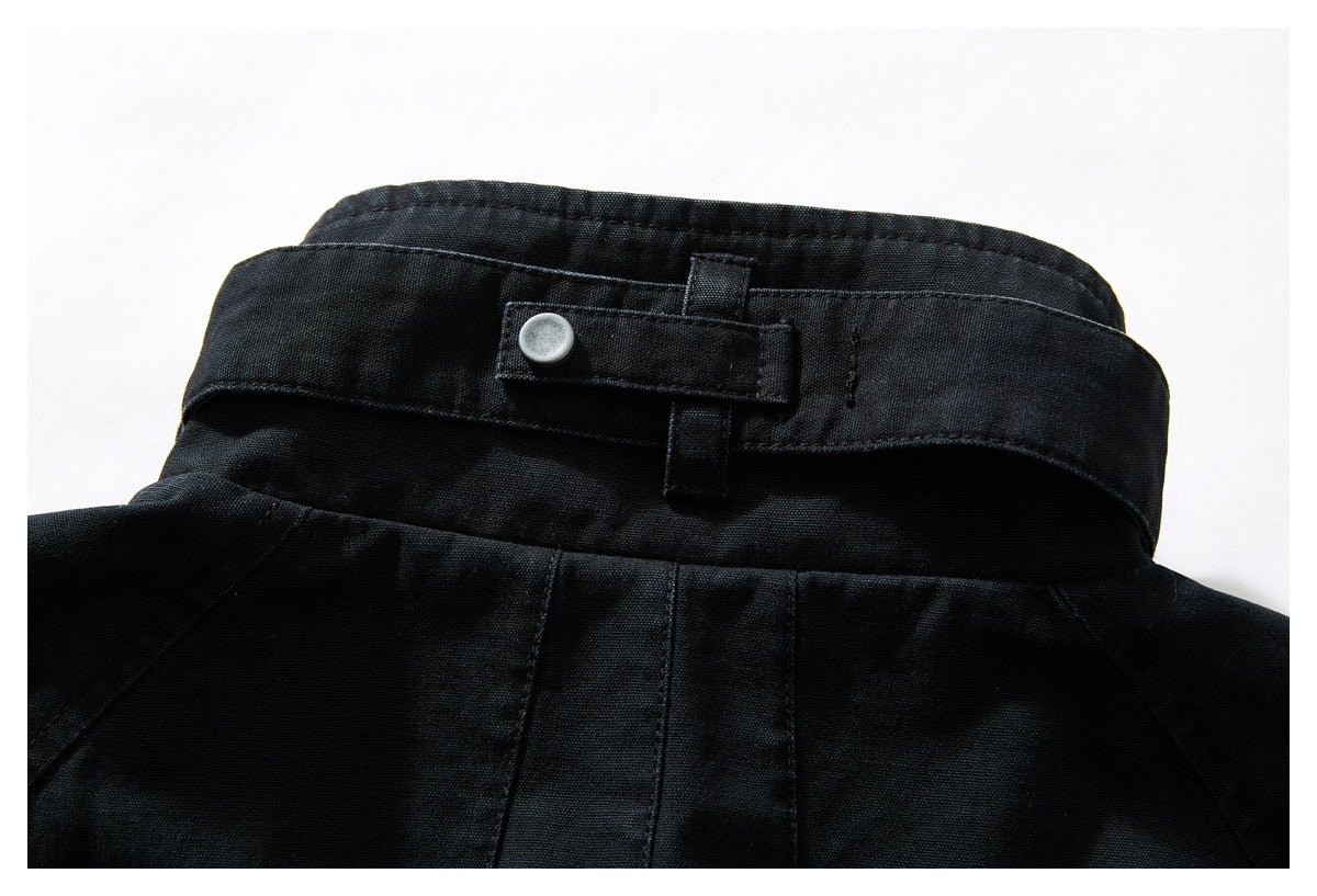 Close-up of a black garment collar with a snap-fastened adjustment tab.