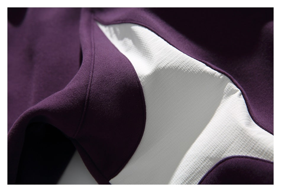 Close-up of dark purple garment fabric and seam against a white surface.