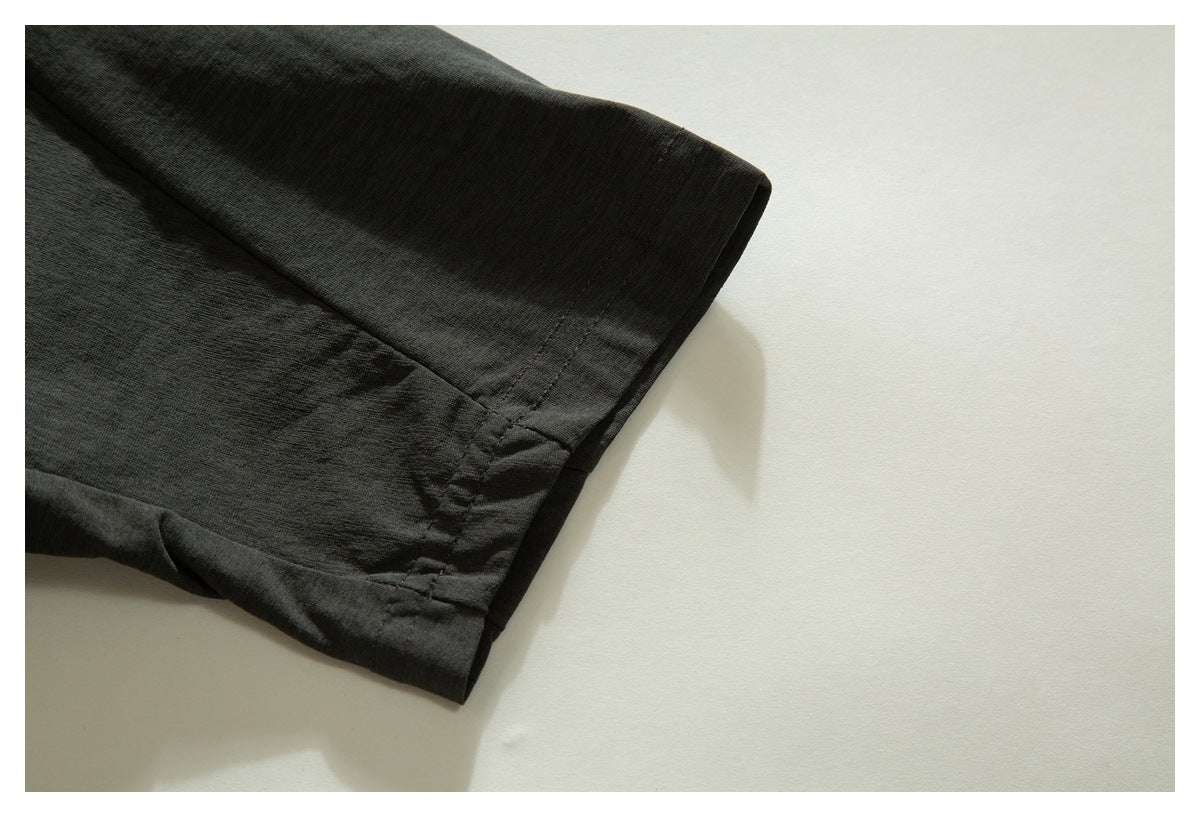 Close-up of a dark charcoal short sleeve and its stitched cuff.