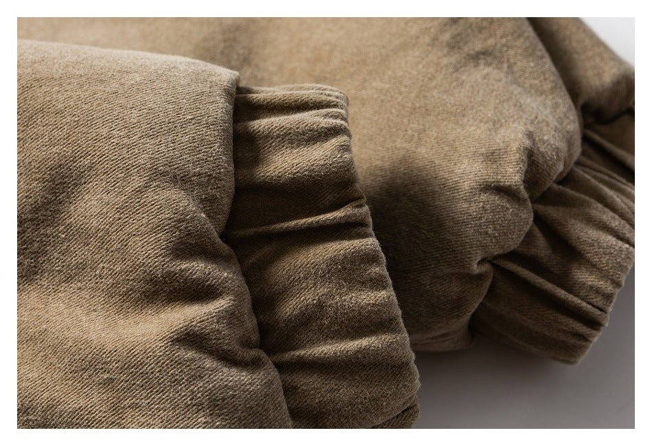 Close-up of a tan garment's gathered elastic cuff and textured fabric.