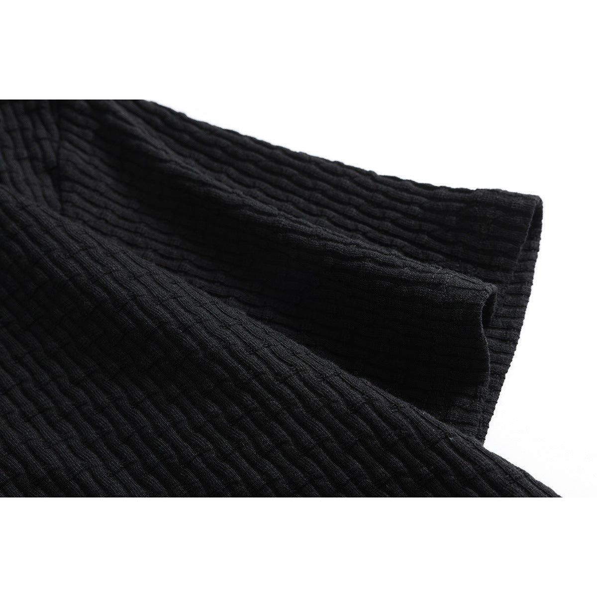 Close-up of the black shirt's short sleeve and stitched sleeve opening, showing its ribbed texture.
