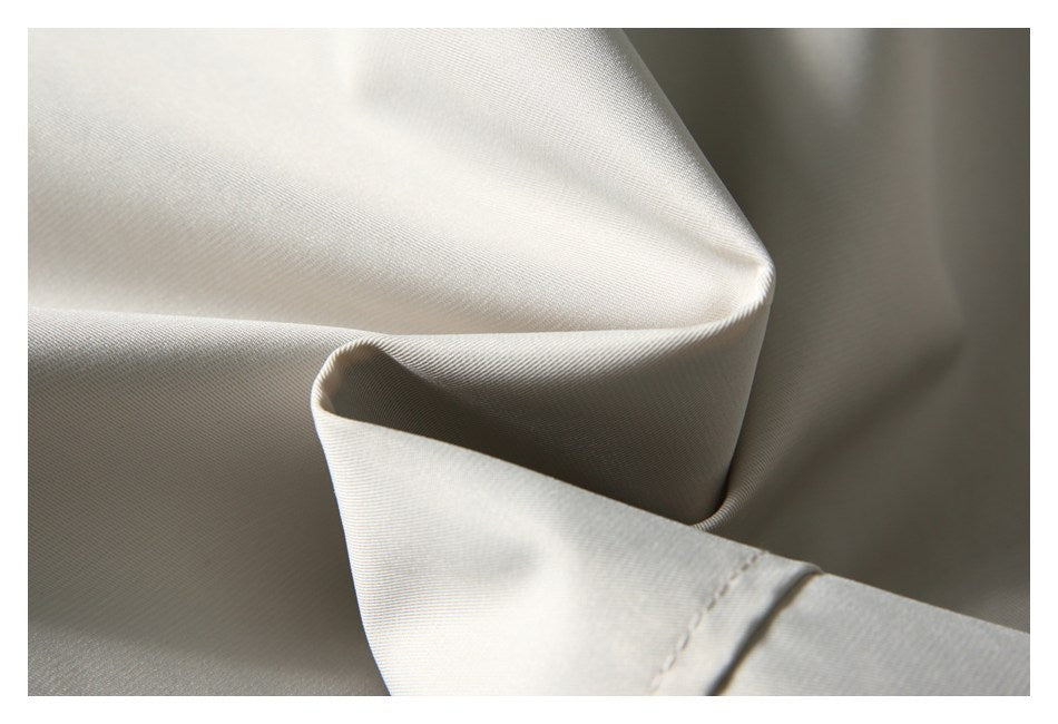 Close-up showing a folded section and fine surface texture of ivory fabric.
