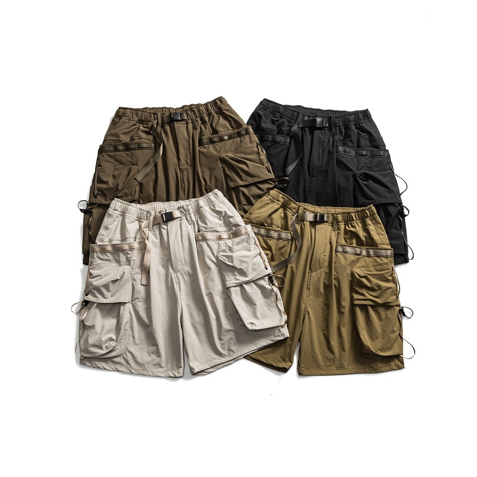 Four pairs of cargo shorts in brown, black, light gray, and olive arranged together, showing front pockets and adjustable