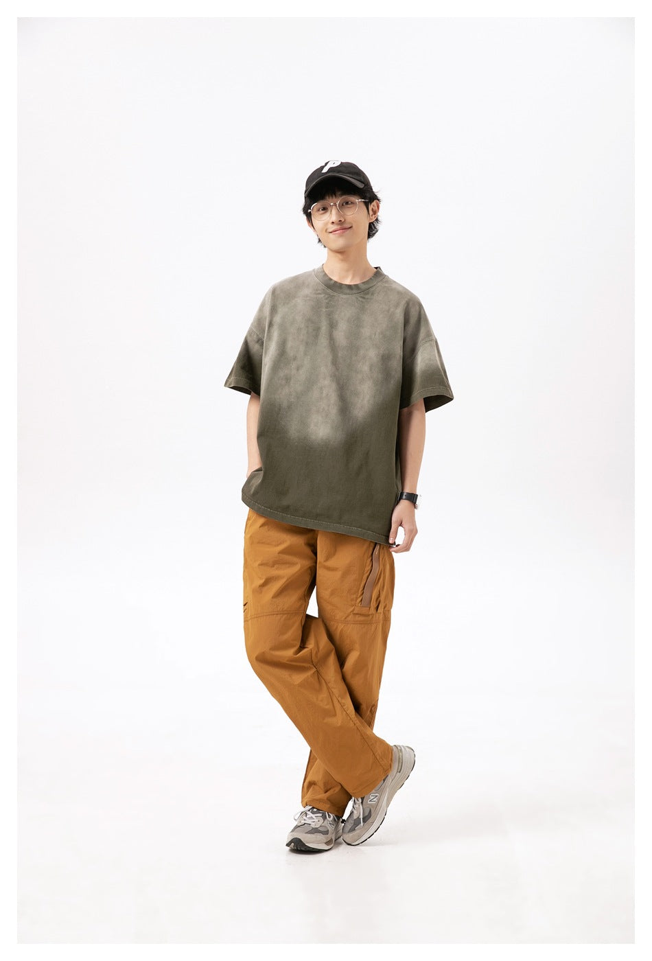 Full-length front view of a model wearing an oversized olive-gray short-sleeve T-shirt with a crew neck.