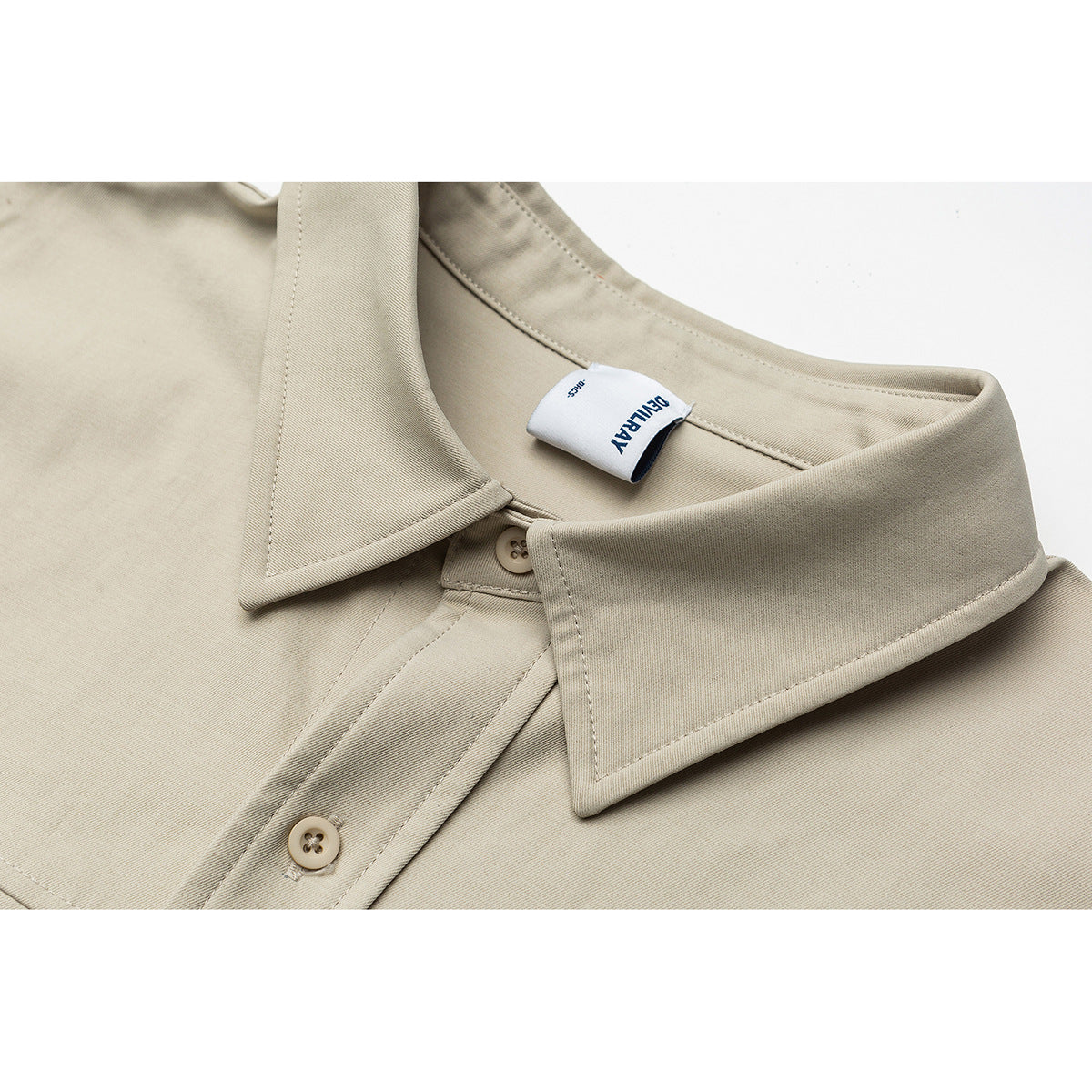 Close-up of a beige shirt collar, button placket, stitching, and a sewn-in neck label.
