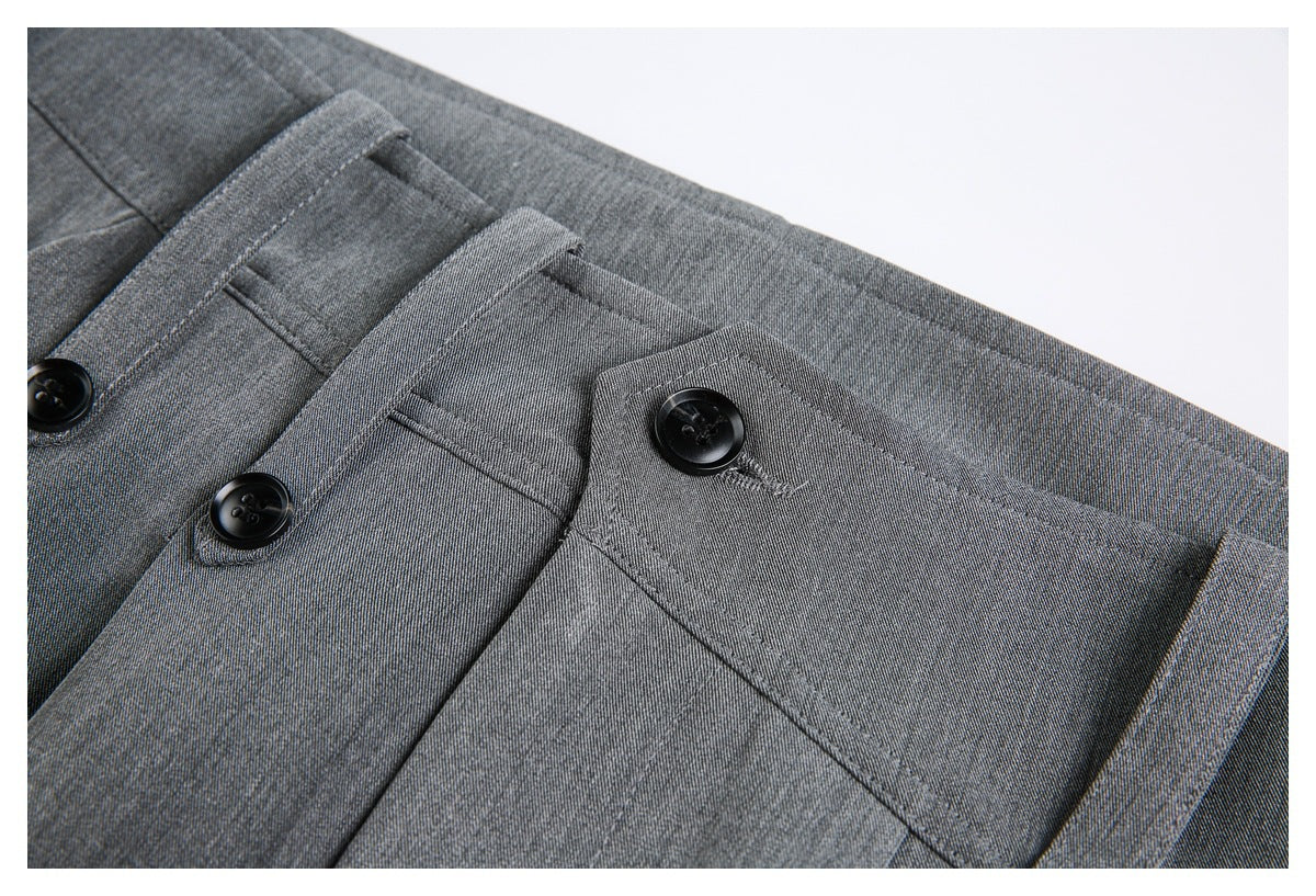 Close-up of gray trouser waistband, belt loops, and black buttons.