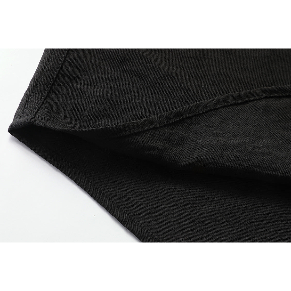 Close-up of the black shirt's curved hem and stitched edge.