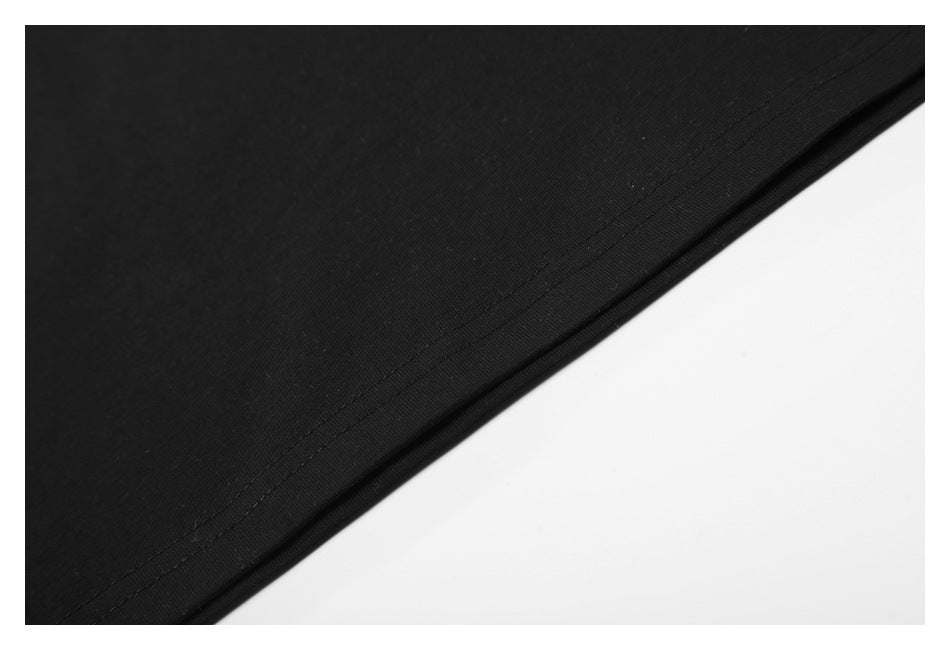Close-up of the double-stitched hem along the edge of black shirt fabric.