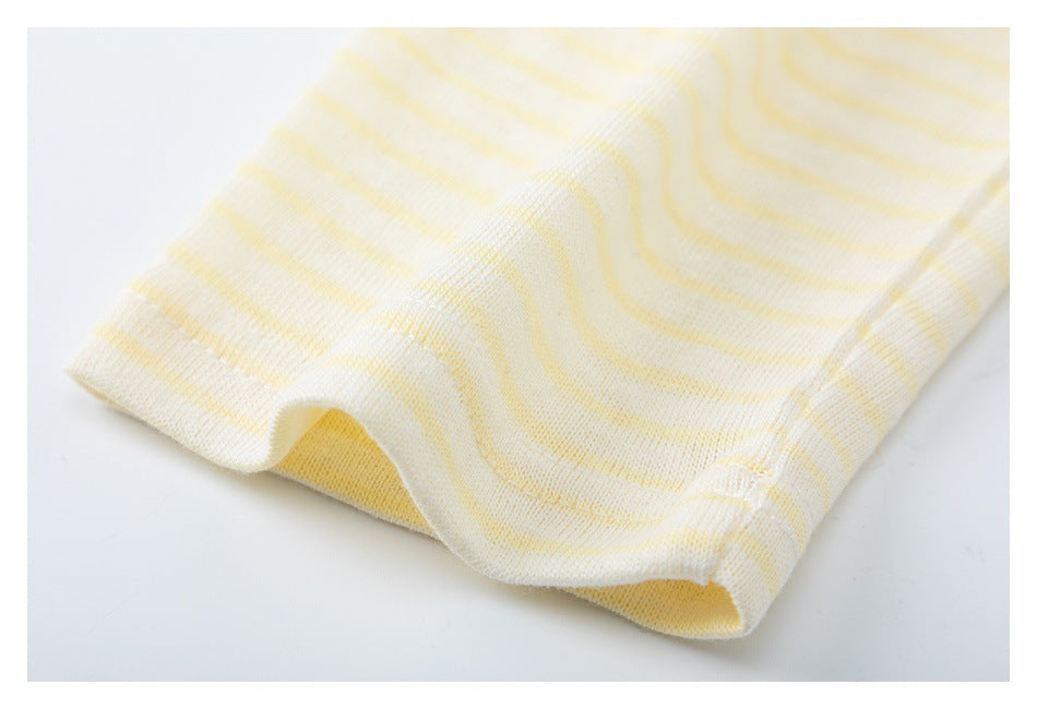 Close-up of the cuff and seam on a cream top with pale yellow stripes.