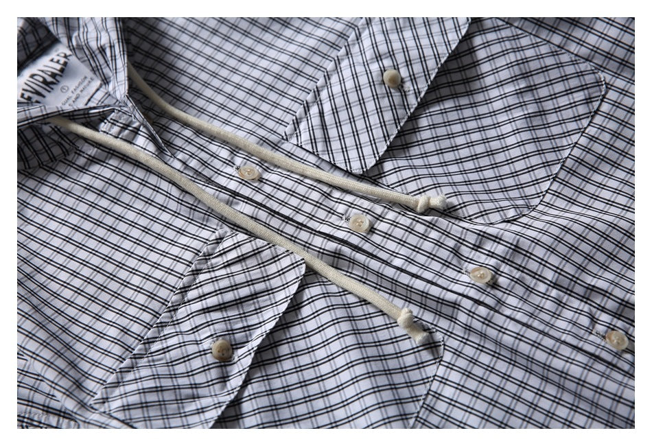 Close-up of the plaid shirt's collar, button placket, and a sewn-in label.