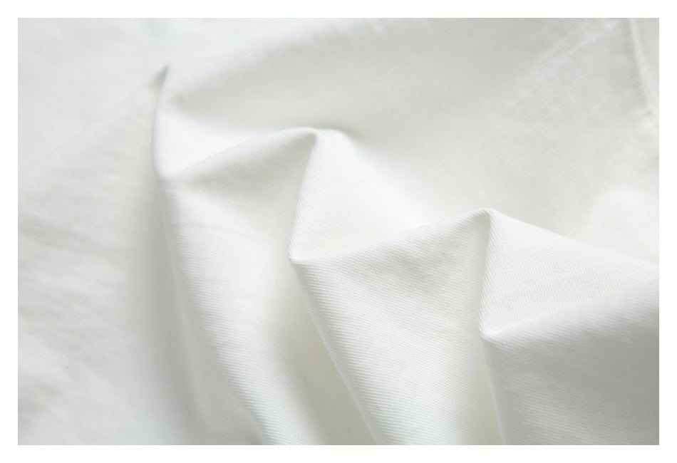 Close-up showing the fine surface texture and soft folds of white garment fabric.