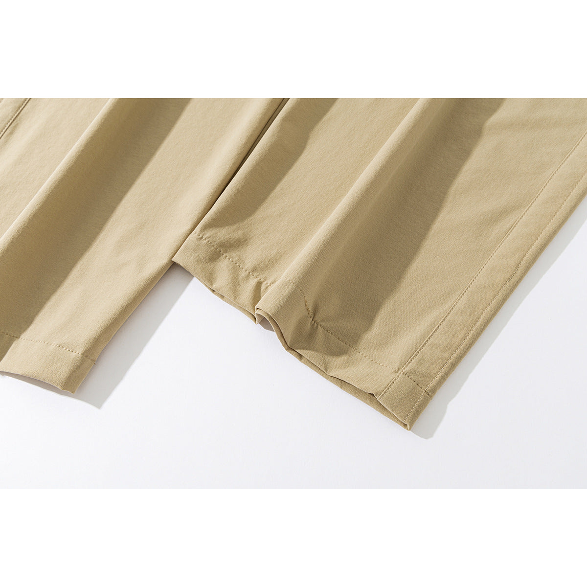 Close-up of tan trouser legs showing the wide hems and stitching.
