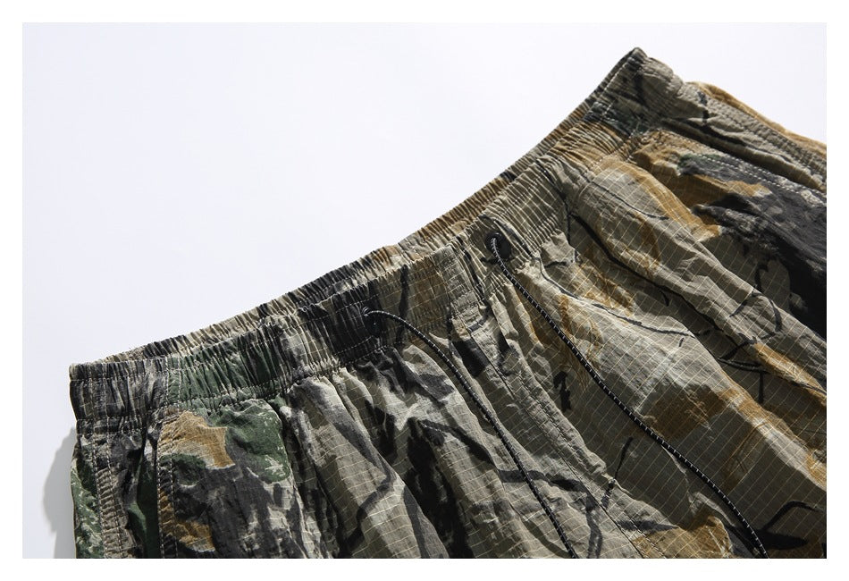 Close-up of the shorts' gathered elastic waistband and black drawstring on the camouflage print.
