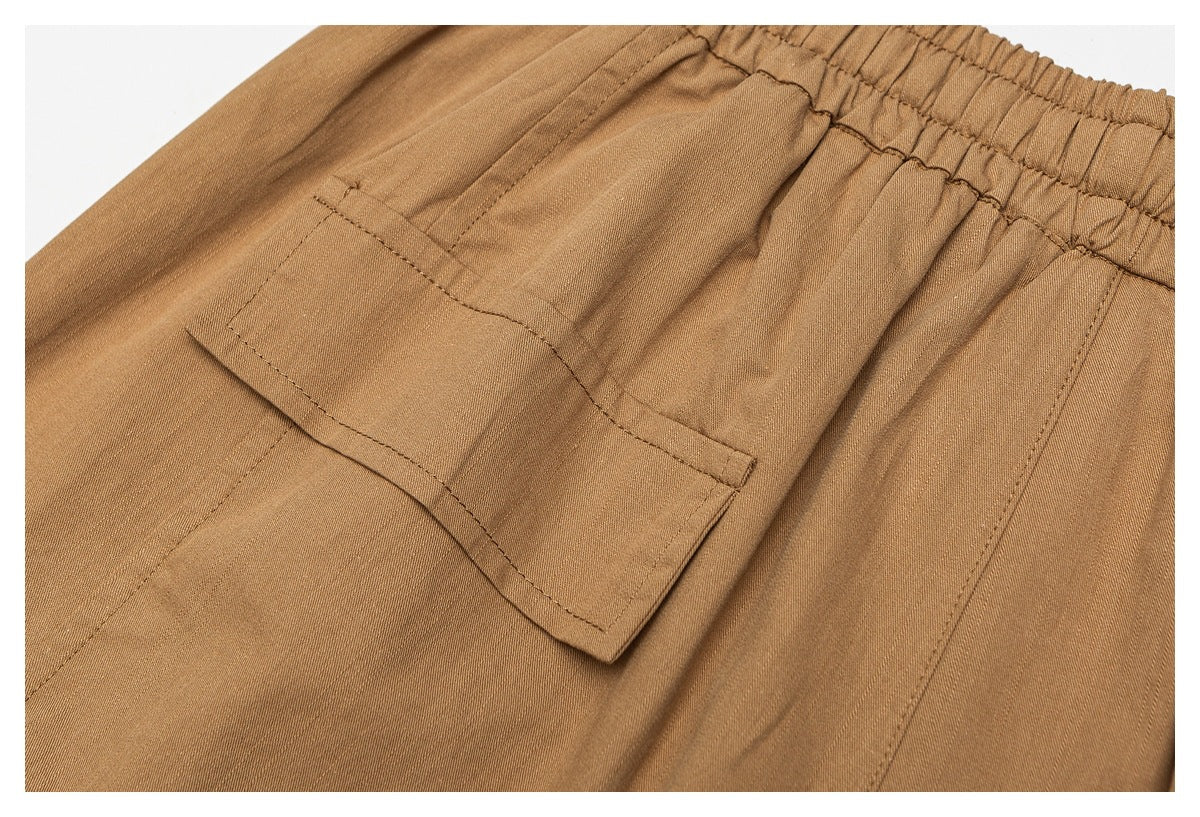 Close-up of a tan trouser patch pocket below an elastic waistband.