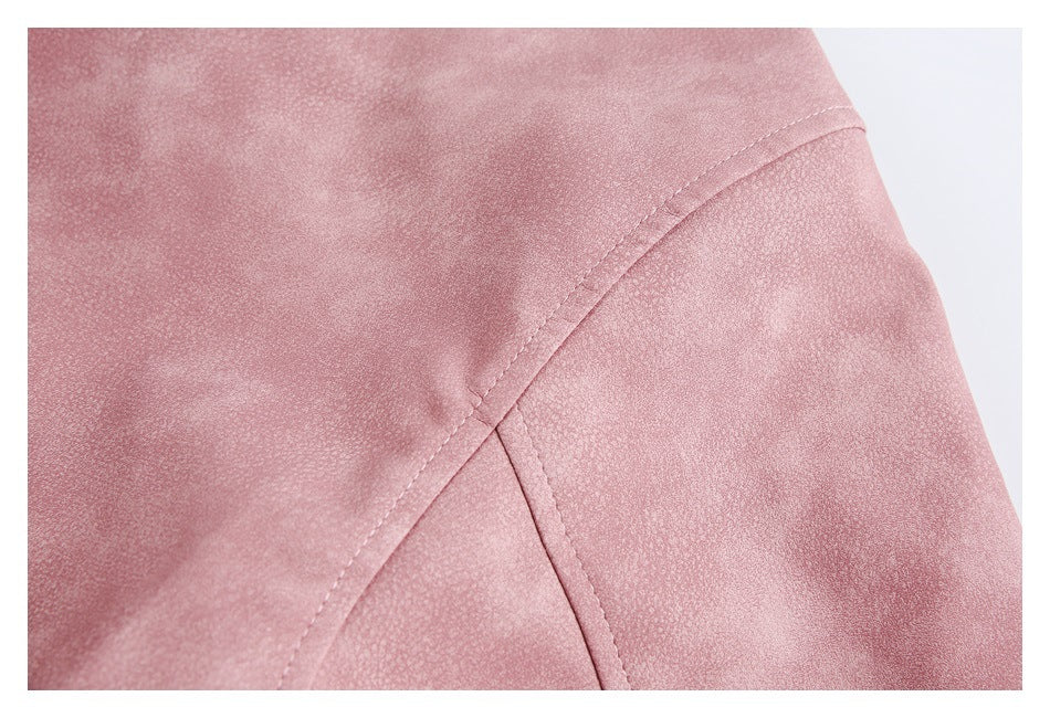 Close-up of intersecting stitched panel seams on a dusty rose jacket.