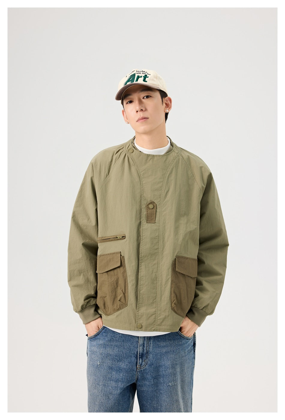 Front view of a model in an olive jacket with contrasting brown flap pockets, a chest zip pocket and snap-front closure.