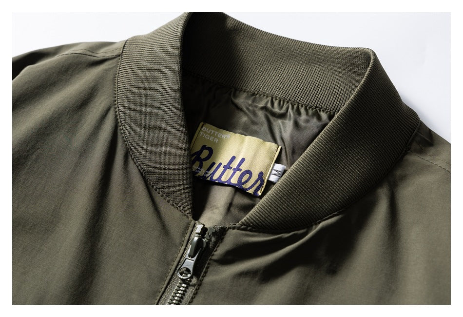 Close-up of an olive bomber jacket's ribbed collar, front zipper and sewn-in brand label.