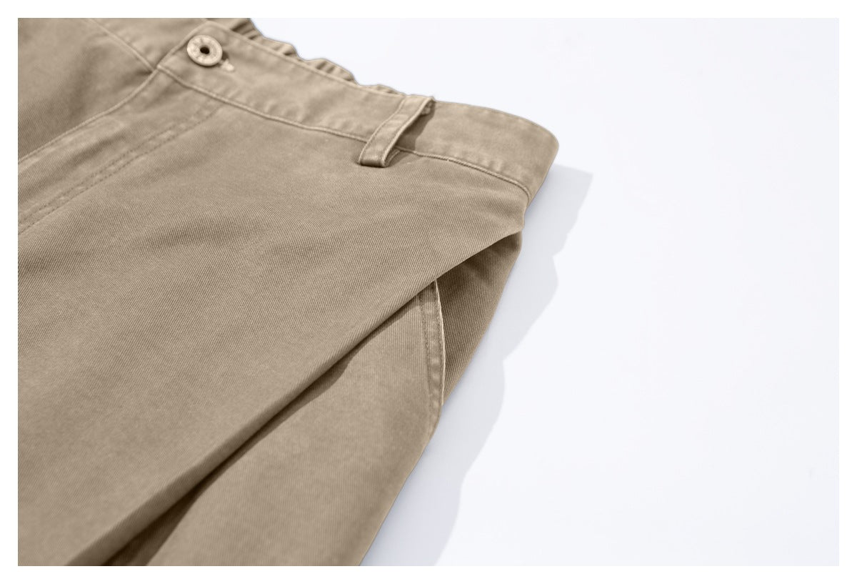 Close-up of tan trousers showing the buttoned waistband and a belt loop.