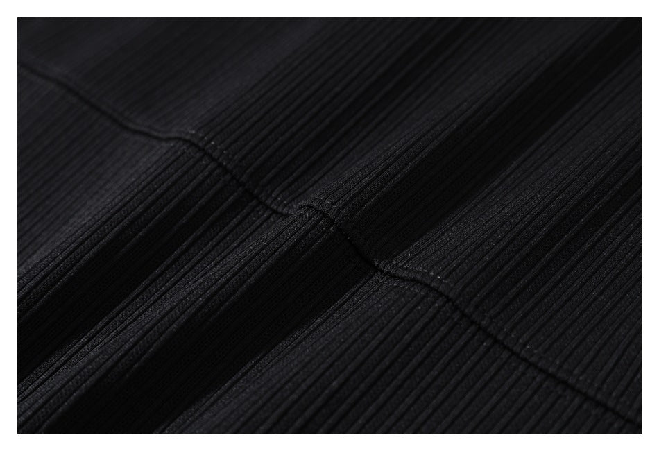 Close-up of black ribbed fabric and a curved stitched seam.