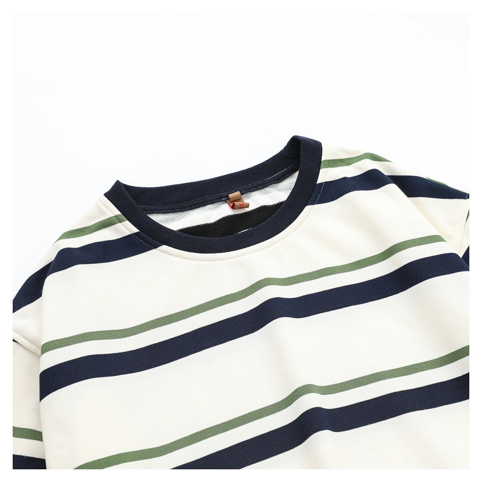 Close-up of the shirt's navy crew neckline and ivory, navy, and olive striped fabric.