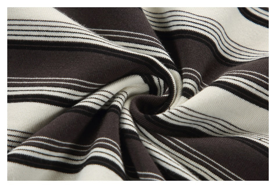 Close-up of cream and dark brown striped knit fabric gathered into folds.