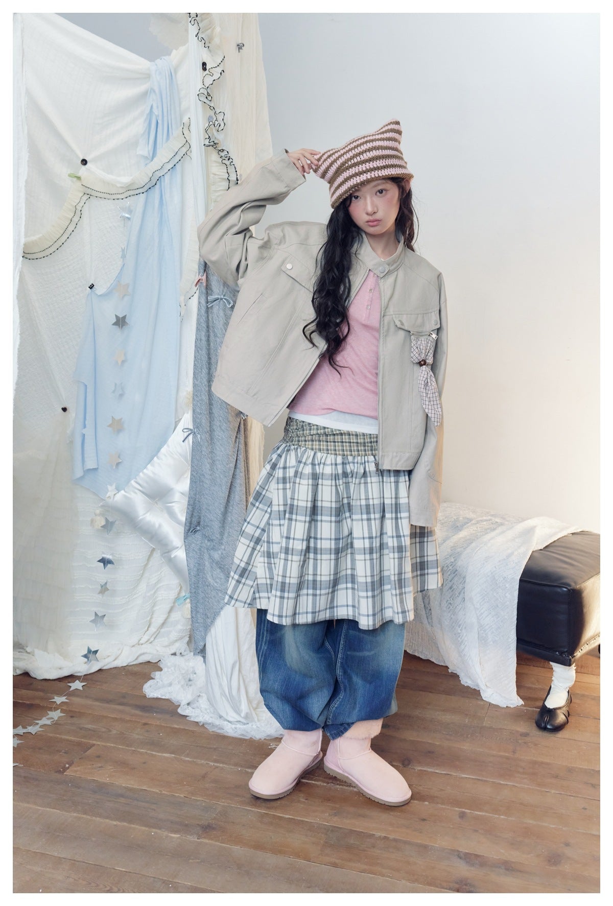 Full-length view of a model wearing a light gray-beige utility jacket with a plaid hanging detail.
