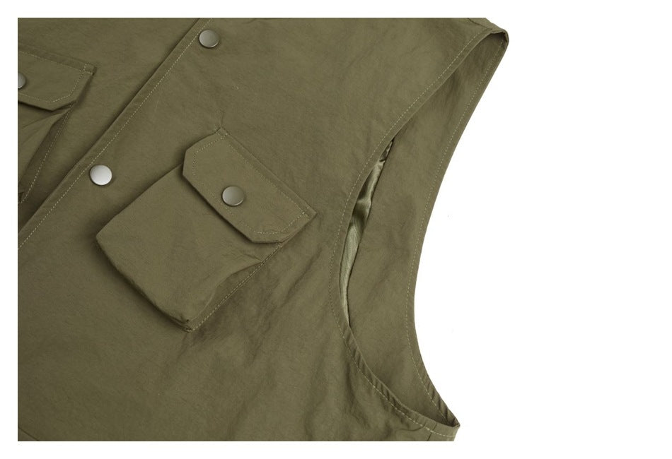 Close-up of an olive jacket's snap-flap pocket and armhole opening.
