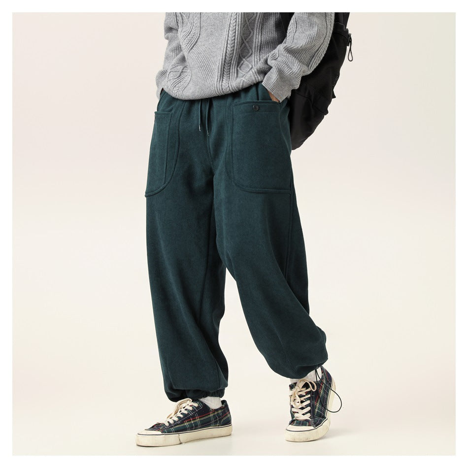 Cropped model wearing dark teal relaxed-fit jogger pants with a drawstring waist and large front pockets.