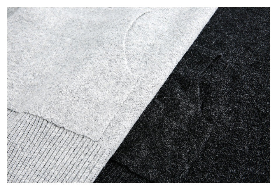 Close-up of light gray and charcoal knitwear with a ribbed edge visible on the gray piece.