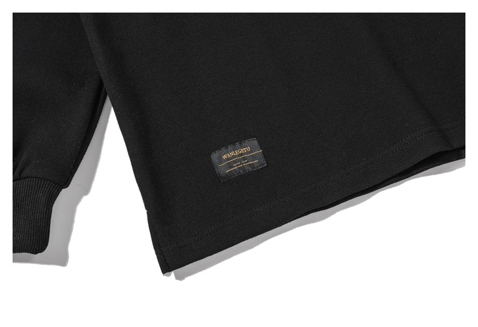 Close-up of the hem and a small sewn label on a black shirt.