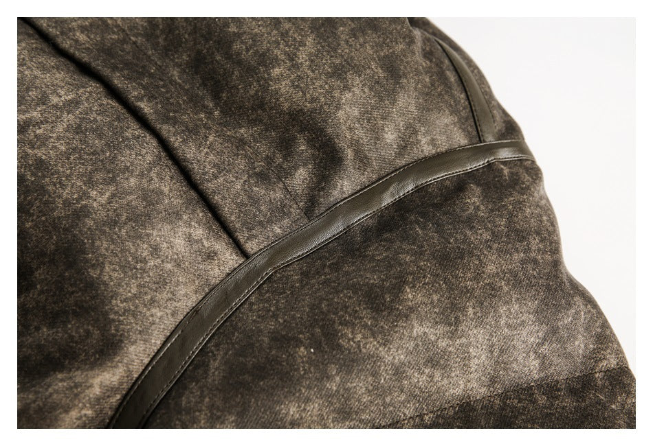 Close-up of a dark curved trim strip and stitched seams on the mottled brown jacket.