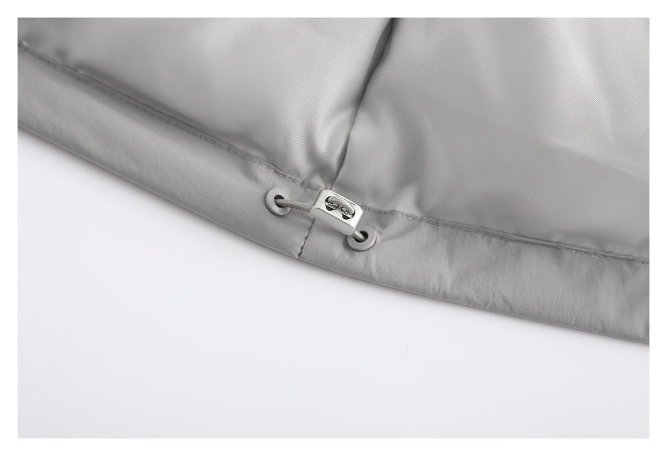 Close-up of a light gray jacket hem with a small adjustable toggle and eyelets.